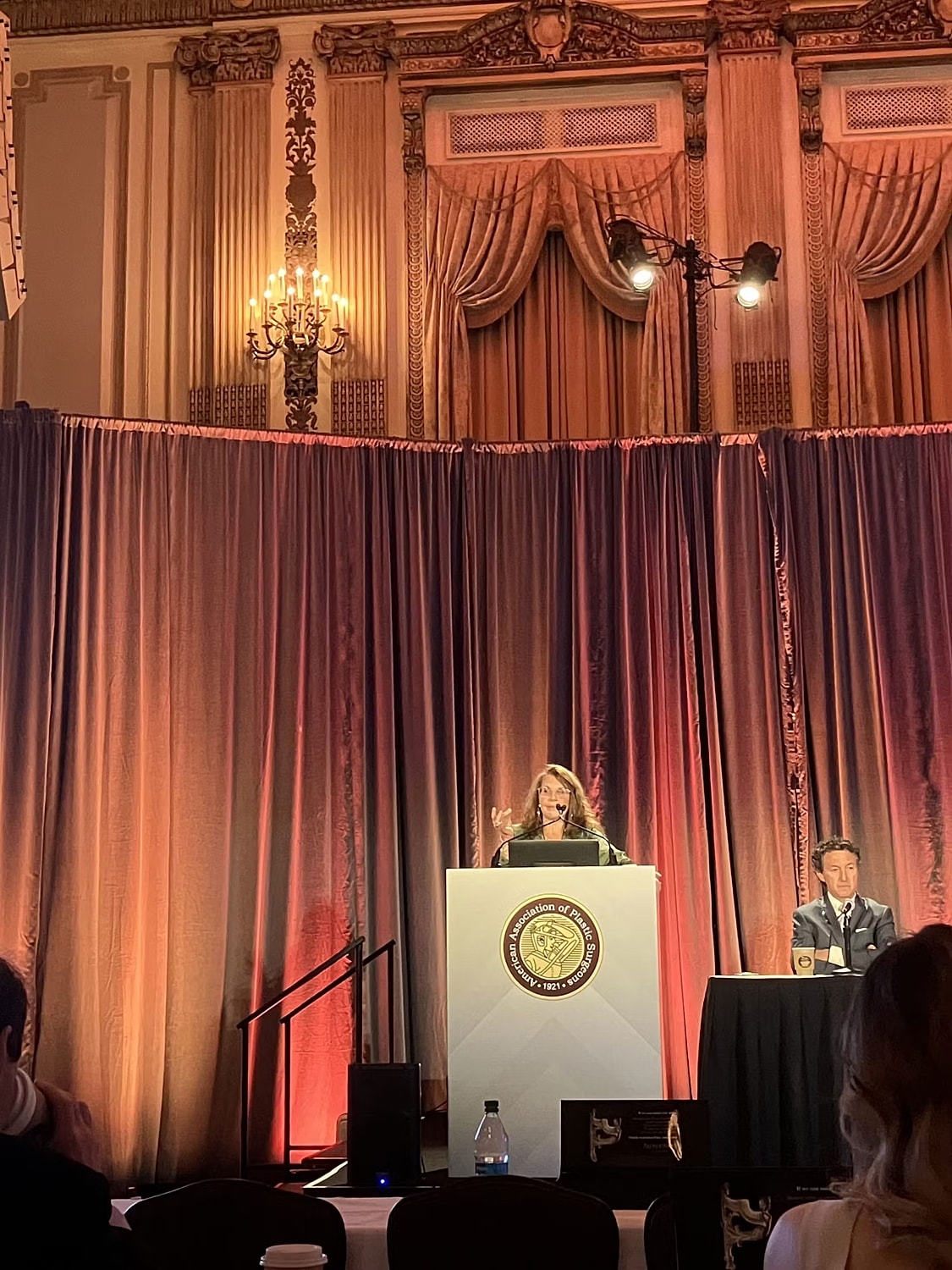 Speaker at podium during a formal event.