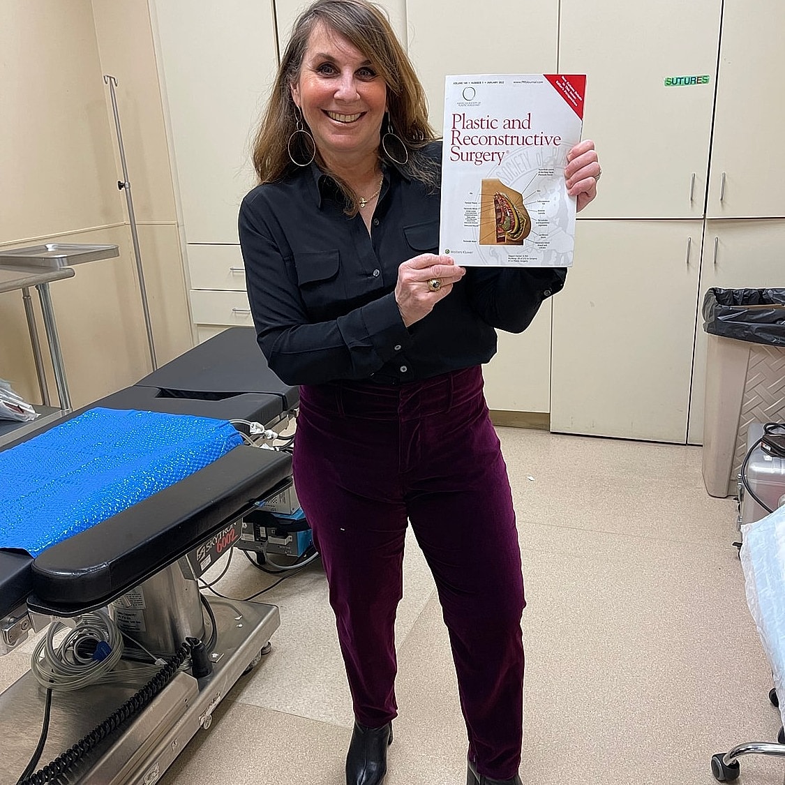 Person holding plastic surgery journal in clinic.