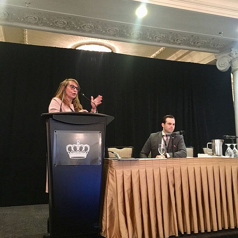 Speaker presenting at a conference panel discussion.