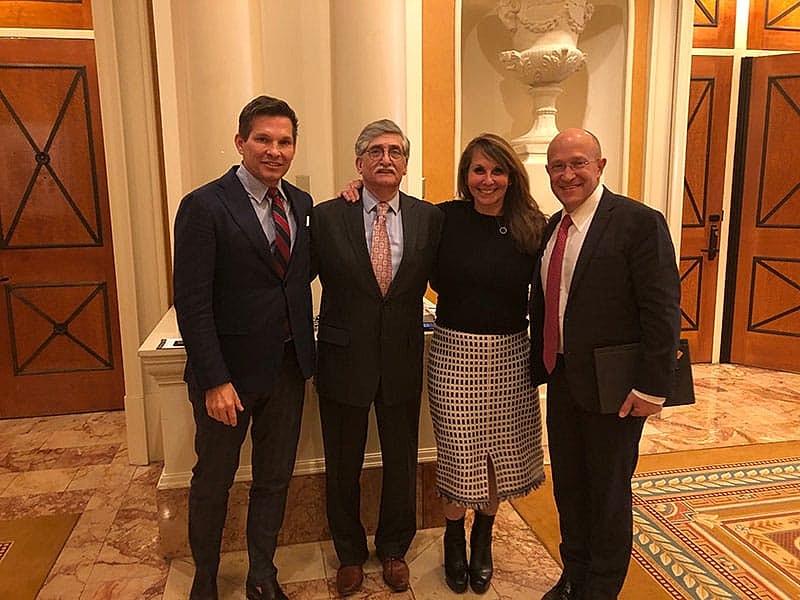 Formal gathering of four individuals indoors.