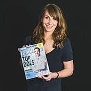 Person holding magazine featuring top doctors.