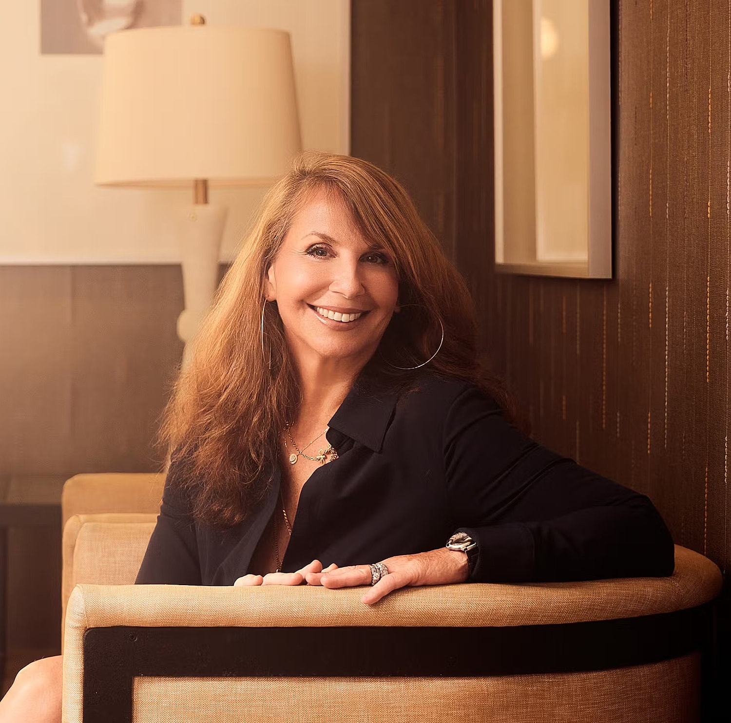 Smiling woman seated in stylish interior.