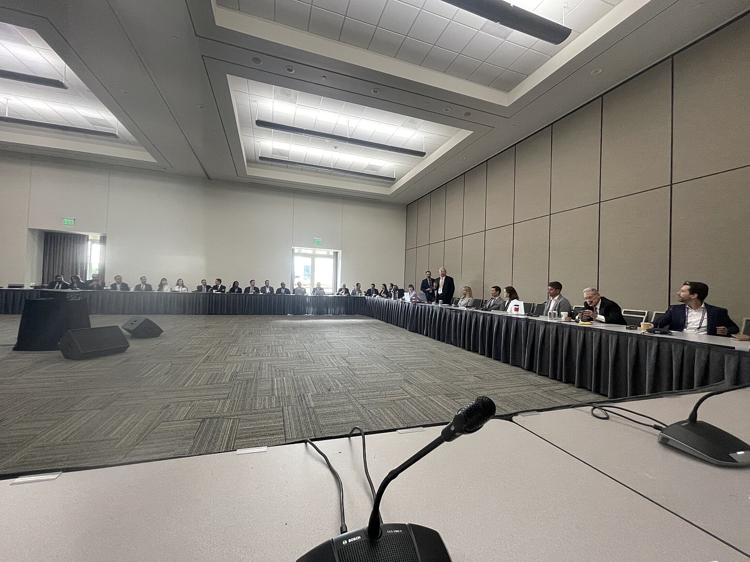 Conference room with attendees engaged in discussion.