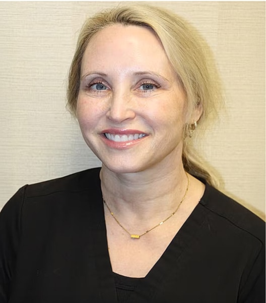 Smiling professional wearing a black scrub top.